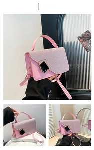 Detailed close-up of pink glittery handbag with gold diamond metal clasp and shoulder strap