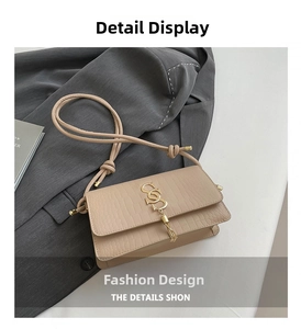 Detail view of beige crocodile embossed shoulder bag with gold SSD logo and fringe