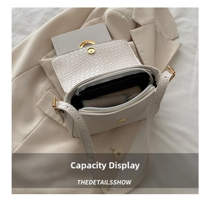 Detail showing the spacious interior of a beige crocodile-embossed handbag with wallet