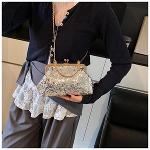 Macro shot of silver sequins shell bag with gold chain strap on a model outfit