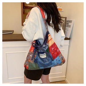 Detail of colorful patchwork tote bag showing ethnic patterns and a decorative bow