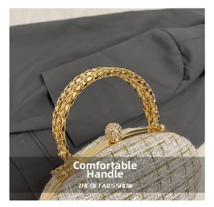 Detail of white tweed texture with gold metal chain handle and crystal clasp on handbag