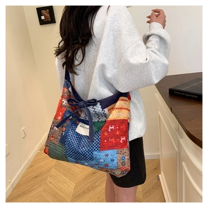 Detail view of a patchwork canvas tote bag with colorful patterns and bow tie closure