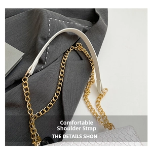 Close-up of white woven shoulder bag featuring gold chain strap and leather detail