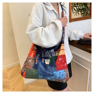 Close-up of ethnic patchwork tote bag featuring geometric patterns and blue bow closure