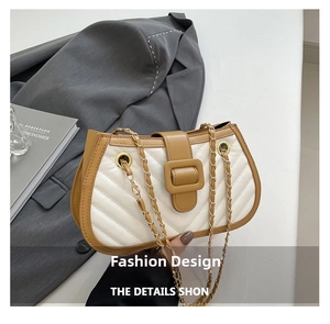 Détail des surpiqûres matelassées et de la chaîne dorée sur le sac bandoulière en cuir