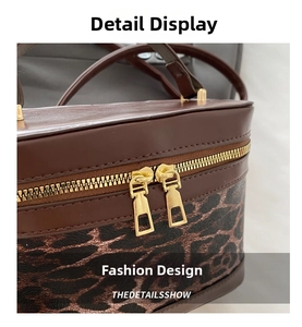 Detail view of leopard print bucket bag featuring premium brown leather and gold zippers