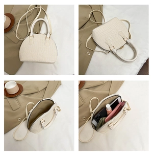 Macro view of cream shell bag showing crocodile pattern texture and spacious interior storage