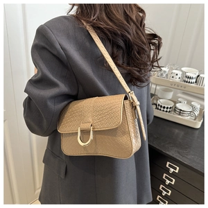 Macro detail of khaki woven texture handbag with golden D-ring metal hardware