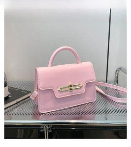 Pink patent leather crossbody bag with elegant gold metal buckle and top handle detail