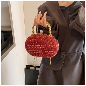 Detail view of red tweed evening bag with gold ring handle and crystal ball clasp