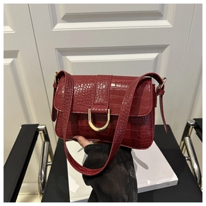 Detail der dunkelroten Kroko-Ledertasche mit eleganter goldener U-förmiger Metallschnalle