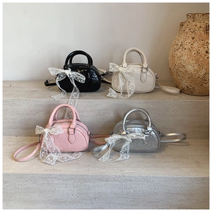 Mini handbags in four colors featuring embossed cartoon patterns and lace bows