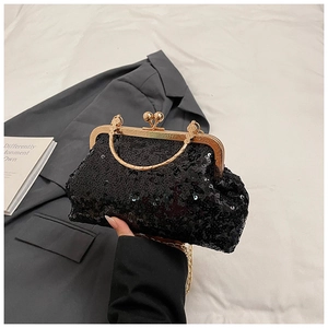 Close-up of black sequin clutch bag with vintage gold frame and beaded metal clasp