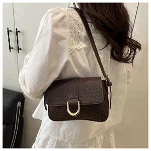 Détail du sac à bandoulière marron foncé texturé avec boucle fer à cheval dorée