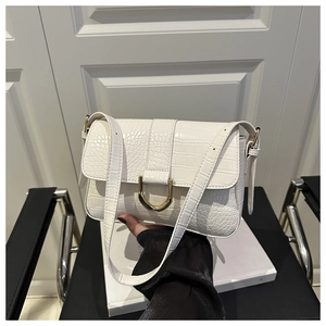 Nahaufnahme der eleganten weißen Handtasche mit Krokodilmuster und goldener U-Metallschnalle