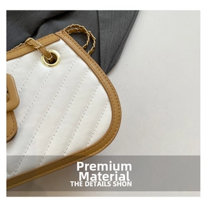 Gros plan sur la texture en cuir PU matelassé avec chaîne dorée sur un sac bandoulière