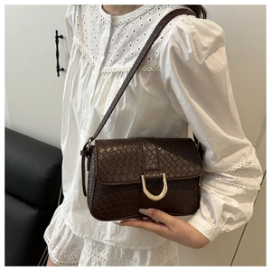 Détail du sac bandoulière en cuir tressé marron foncé avec boucle en métal doré
