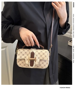 Detail of retro floral square handbag with brown leather strap and gold hardware clasp