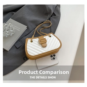 Détail du sac bandoulière matelassé blanc avec bordure marron et chaîne dorée sur blazer gris