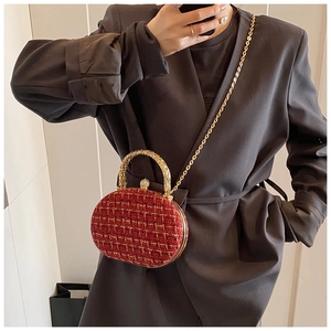Detail of red tweed handbag with gold chain handle and rhinestone buckle on blazer