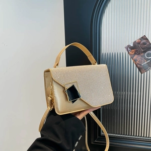 Champagne gold glitter flap handbag with black geometric metal buckle and top handle strap