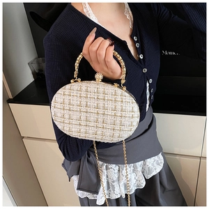 Detail of tweed crossbody bag with elegant gold chain handle and sparkling crystal ball clasp