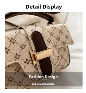 Detailed close-up of retro cream white satchel with brown monogram pattern and gold metal lock