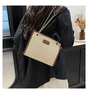 Gros plan sur la texture tissée et l'inscription FASHION du sac sous l'aisselle