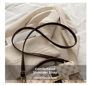Detail of adjustable leather strap and gold hardware on retro patterned crossbody bag