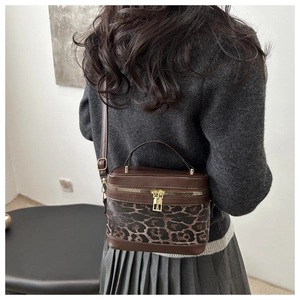 Rear view of a model wearing the brown leopard print box bag as a crossbody accessory