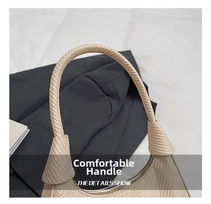 Detail showing the thick integrated woven handle of the beige straw shoulder bag