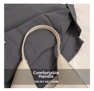 Detailed close-up of wide braided beige shoulder strap with elegant woven texture