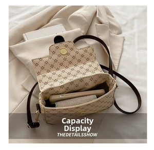 Detail view of the spacious inner compartment of the beige quilted crossbody bag