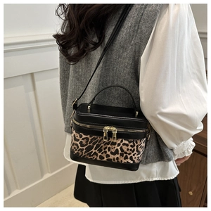 Model view of leopard print crossbody bag with sleek black paneling and gold zippers