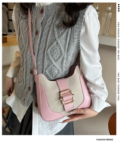 Detailed view of vintage pink leather and beige canvas patchwork crossbody bag with buckle