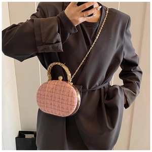 Pink tweed shell bag shown on model with gold chain strap and metal handle