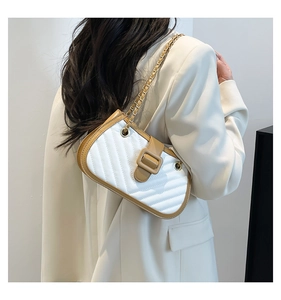 Détail du sac à main matelassé blanc avec bordure marron et bandoulière chaîne