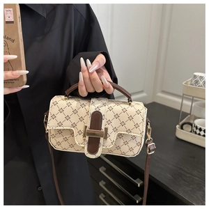 Detail of vintage patterned crossbody bag with gold buckle and fine leather texture