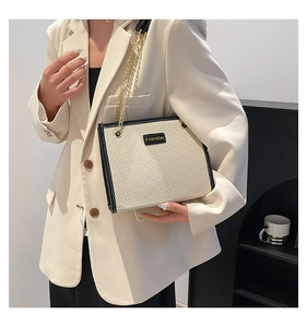 Détail du cabas crème avec étiquette FASHION noire et élégante chaîne dorée