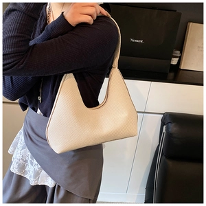 Detailed view of beige hobo bag showing woven texture and elegant curved zipper closure