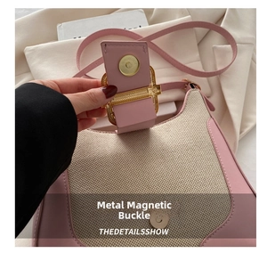 Detail of magnetic snap closure and gold hardware on pink leather canvas bag