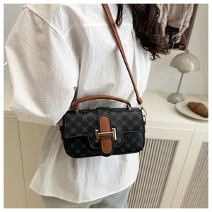 Detail of a mini crossbody bag featuring star patterns and brown leather strap on model