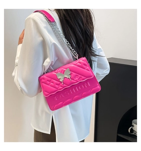Close-up of fuchsia quilted bag with silver butterfly clasp and fashion embossed detail