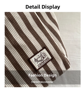 Detail of striped canvas tote bag featuring a vintage camping patch and ribbed texture