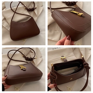 Dettagli di una borsa a tracolla in pelle marrone con fibbia dorata e spallina annodata