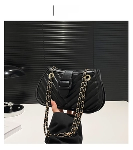 Détail du sac bandoulière noir matelassé avec motif en V et chaîne en métal doré