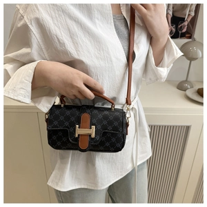 Detailed view of vintage crossbody bag with grey diamond patterns and brown leather straps
