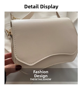 Detail of beige square shoulder bag featuring wavy flap and golden D-ring hardware