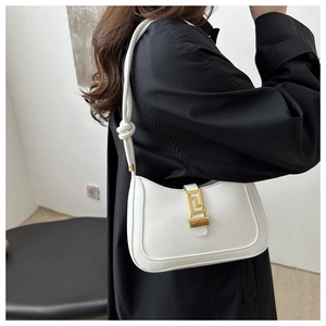 Dettaglio della borsa a spalla in pelle bianca con l'esclusiva chiusura geometrica in metallo oro